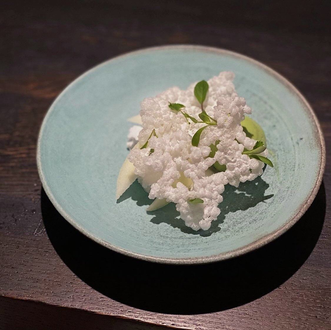 A sea-foam glazed plate carrying a composed fish dish