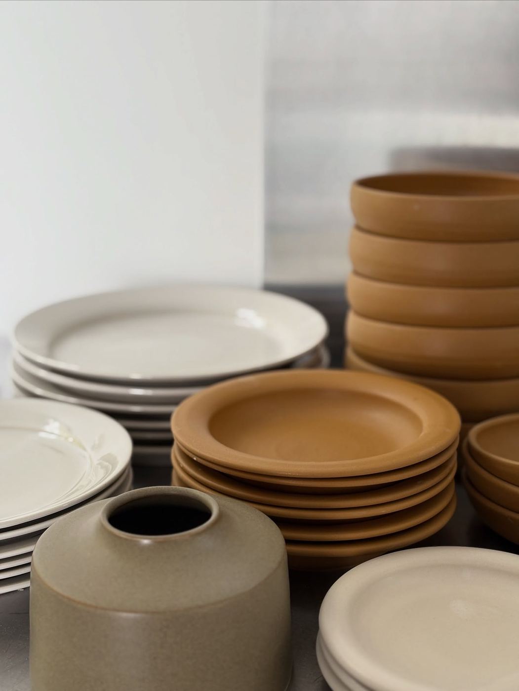 Stockholm studio shelves with vases and stacks of ceramic plates