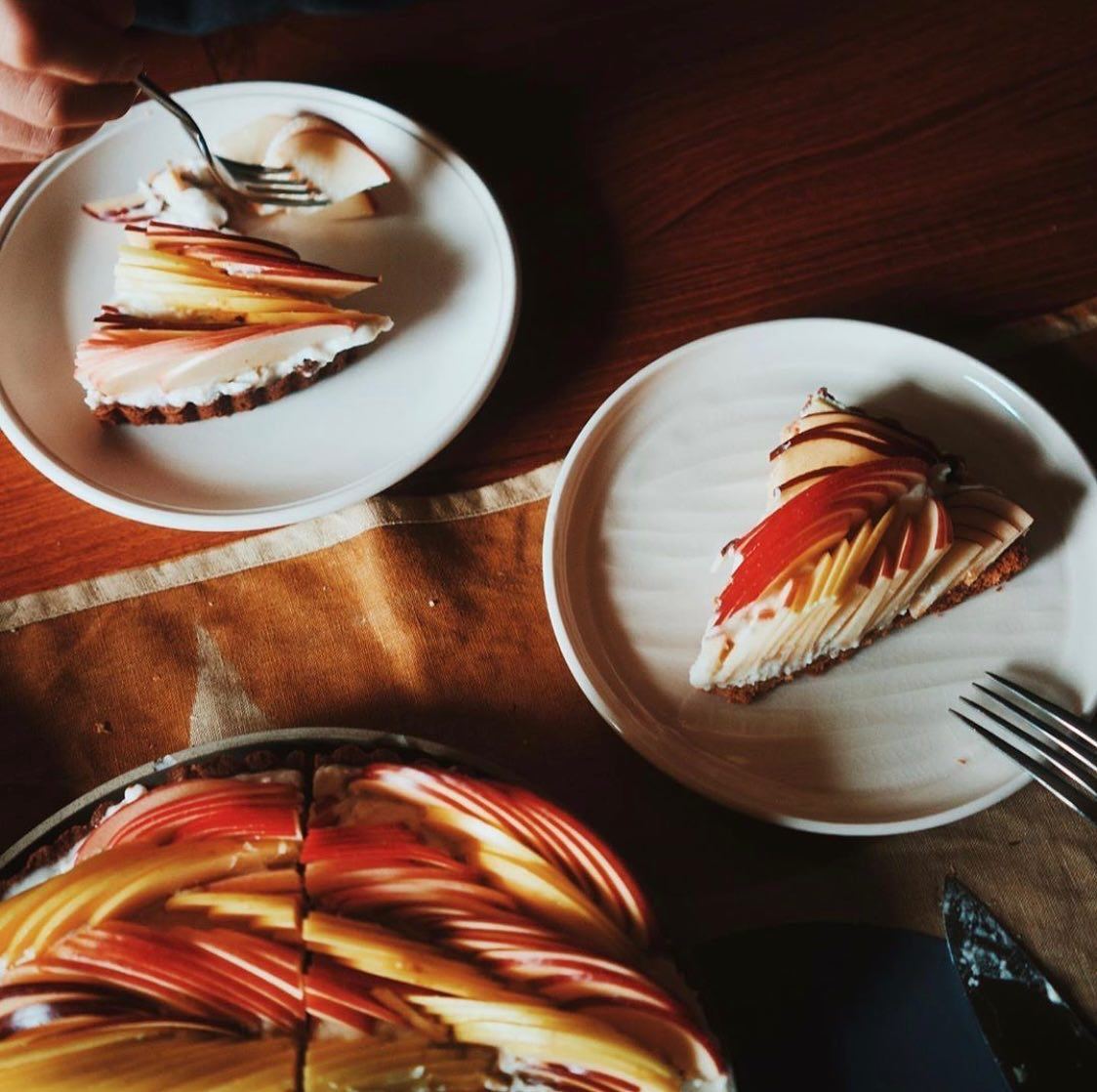 An endive course served on ceramic side plates in warm restaurant light