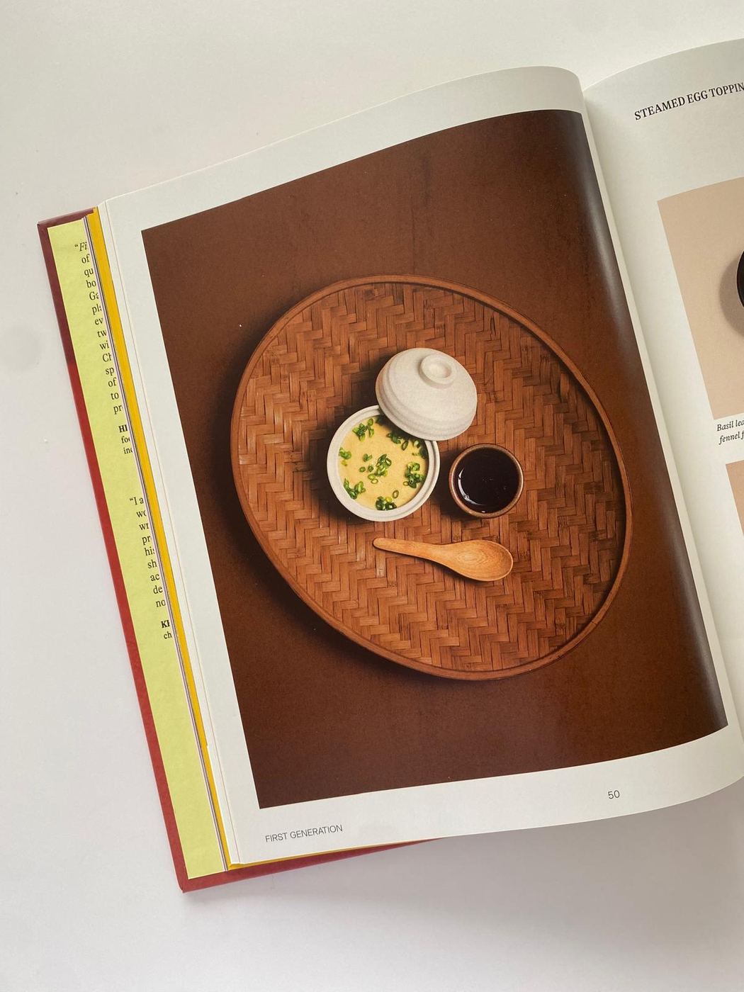 Open cookbook showing steamed egg served in a dark ceramic bowl on page 50