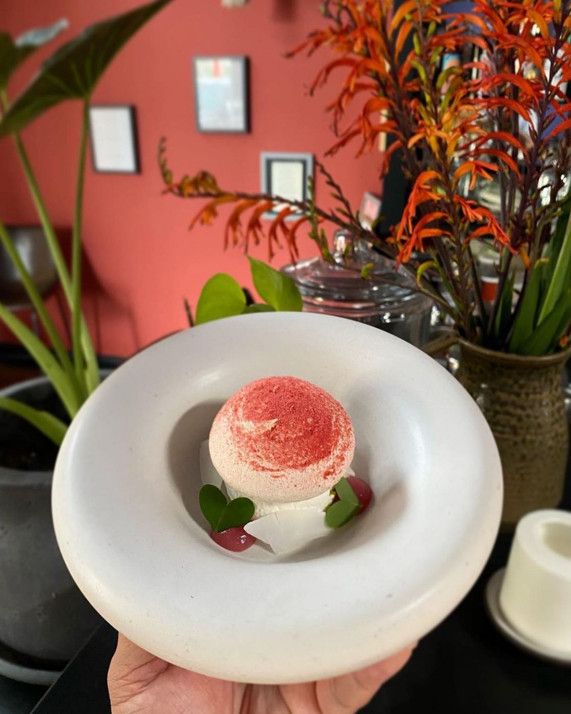 Coconut lychee hibiscus pavlova served in a white ceramic bowl at Mago